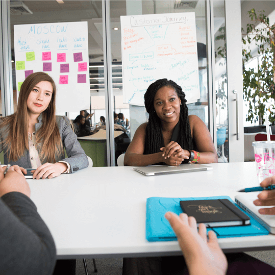 Earng Media image of people chatting over table workplace.